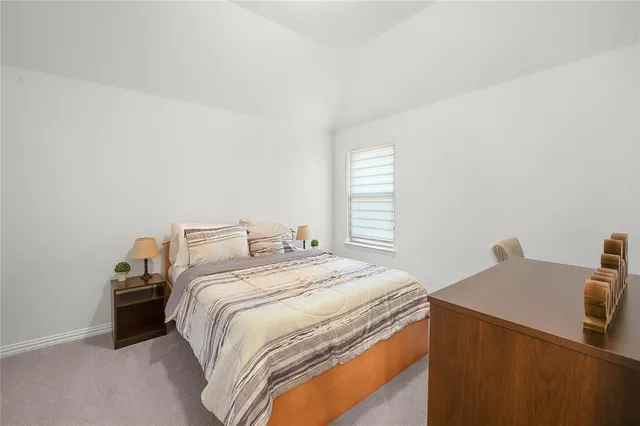 a bedroom with a bed and two windows