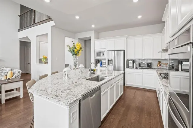 a kitchen with kitchen island granite countertop lots of counter top space and stainless steel appliances