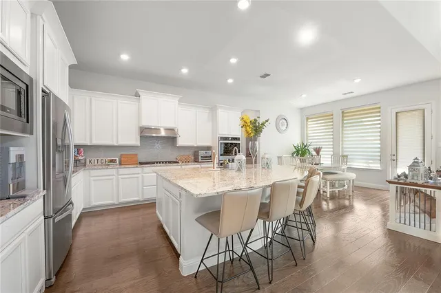 a large kitchen with kitchen island a large island in it