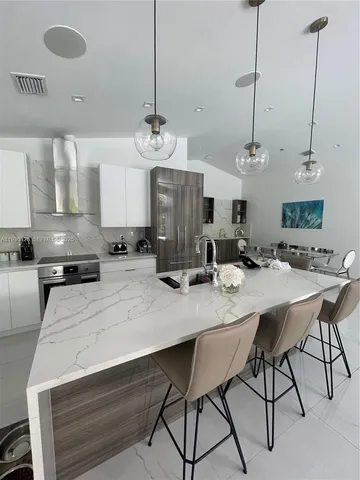 a kitchen with a stove white cabinets and white appliances