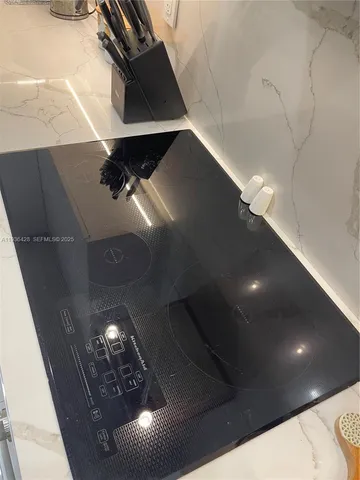 a view of kitchen with sink a island and chairs