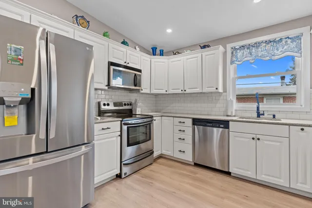 a kitchen with stainless steel appliances granite countertop a refrigerator sink and stove
