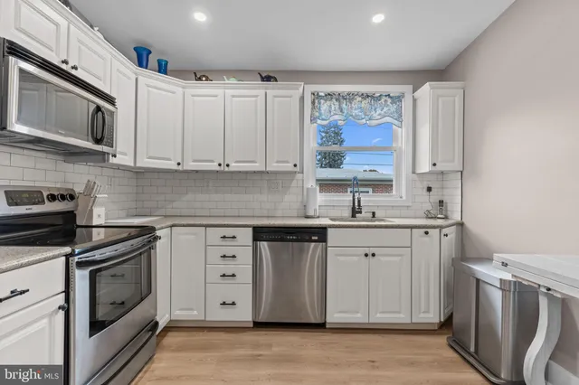 a kitchen with stainless steel appliances granite countertop a stove sink and cabinets
