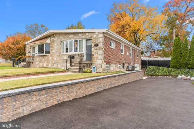 a front view of house with yard and trees in the background