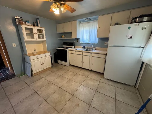 a kitchen with a refrigerator a stove top oven and a sink