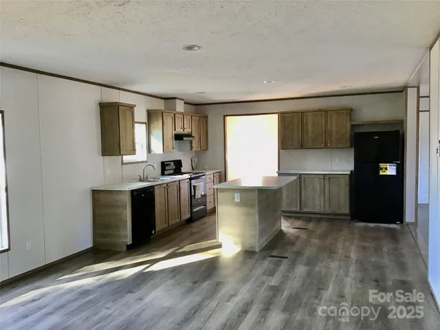 a kitchen with a sink cabinets and wooden floor
