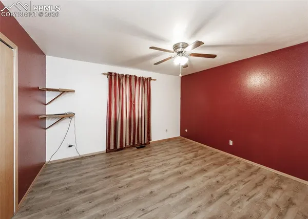 an empty room with wooden floor and bathroom view