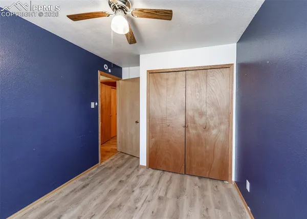 a room with a wooden floor and potted plant