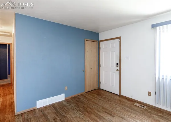 a view of an empty room with wooden floor