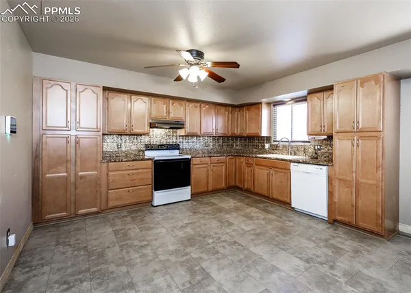 a kitchen with stainless steel appliances granite countertop a stove sink cabinets and window