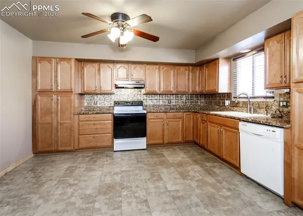 a kitchen with white cabinets and white appliances