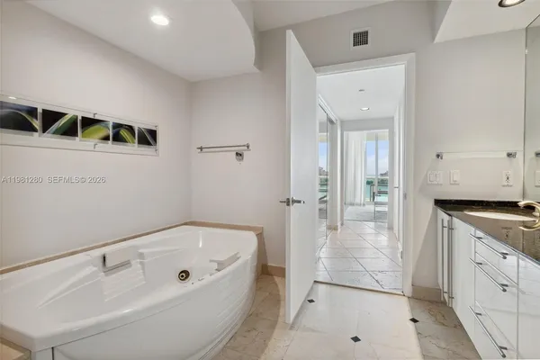 a bathroom with a shower sink vanity mirror and toilet
