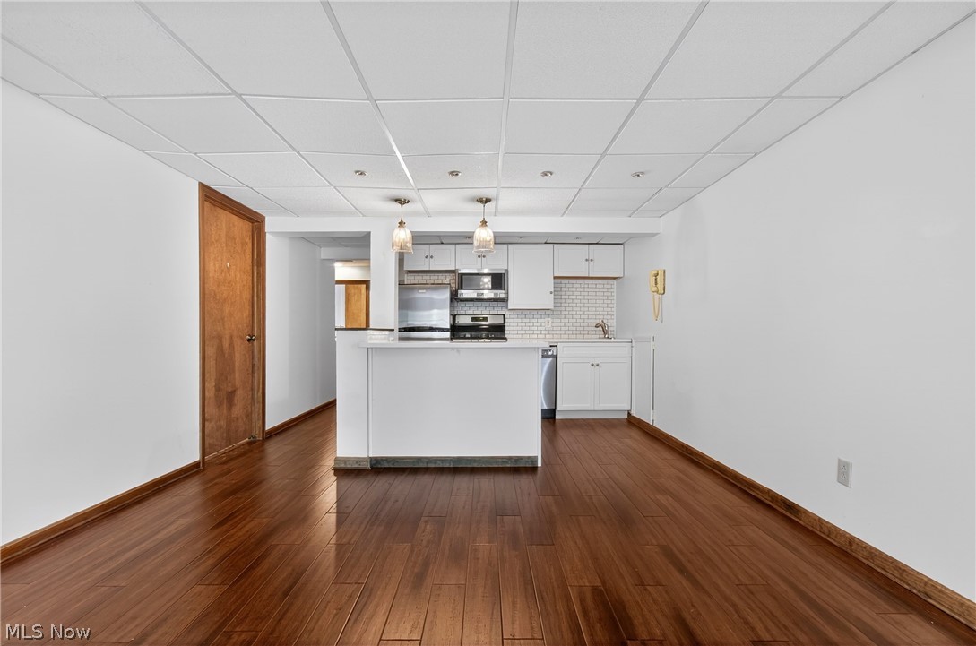 5346 Burlawn Street Northwest Canton, OH 44708 - Photo 28 of 40 Open-concept space featuring rich wood-finish flooring, a contemporary kitchen, white cabinetry, a subway tile backsplash, and recessed lighting