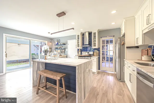 a kitchen with kitchen island stainless steel appliances a center island and a sink