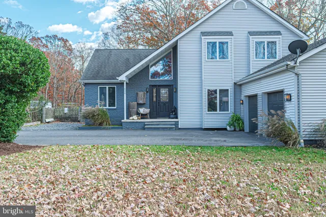 a view of a yard in front of a house with large tree