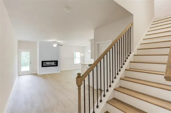 a view of staircase with lots of frames on wall and a window