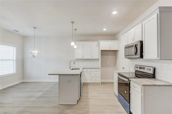 a kitchen with stainless steel appliances kitchen island granite countertop a stove a sink and a refrigerator