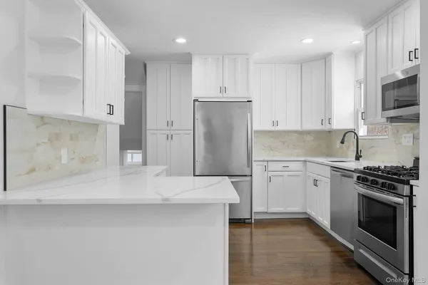 a kitchen with stainless steel appliances granite countertop a refrigerator sink and stove