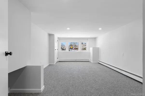 a view of a livingroom with wooden floor and white walls