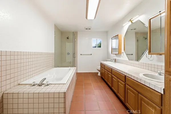 a spacious bathroom with a double vanity sink mirror and bathtub