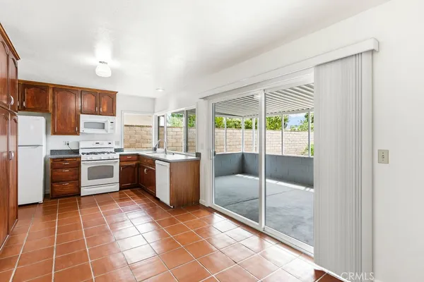 a large kitchen with a stove a refrigerator a sink dishwasher with a dining table and chair