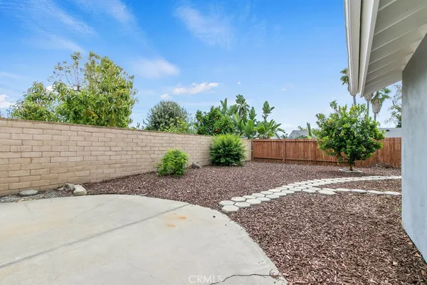 a front view of a house with a yard and potted plants