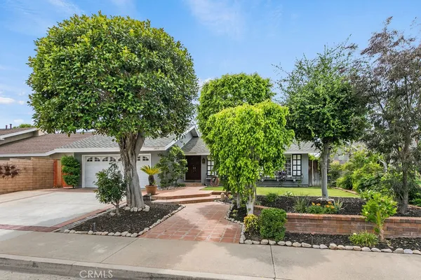 a front view of a house with a tree