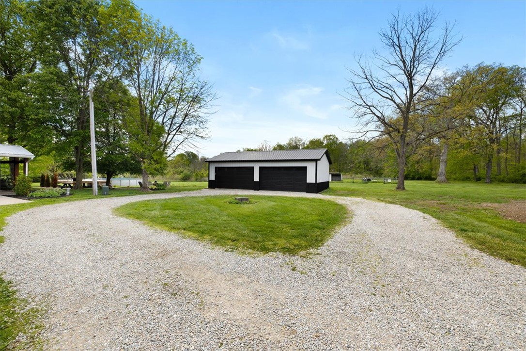 5120 Wheelock Road Troy, OH 45373 - Photo 53 of 67 This expansive property features a detached garage and a generous gravel driveway, offering ample space and utility.
