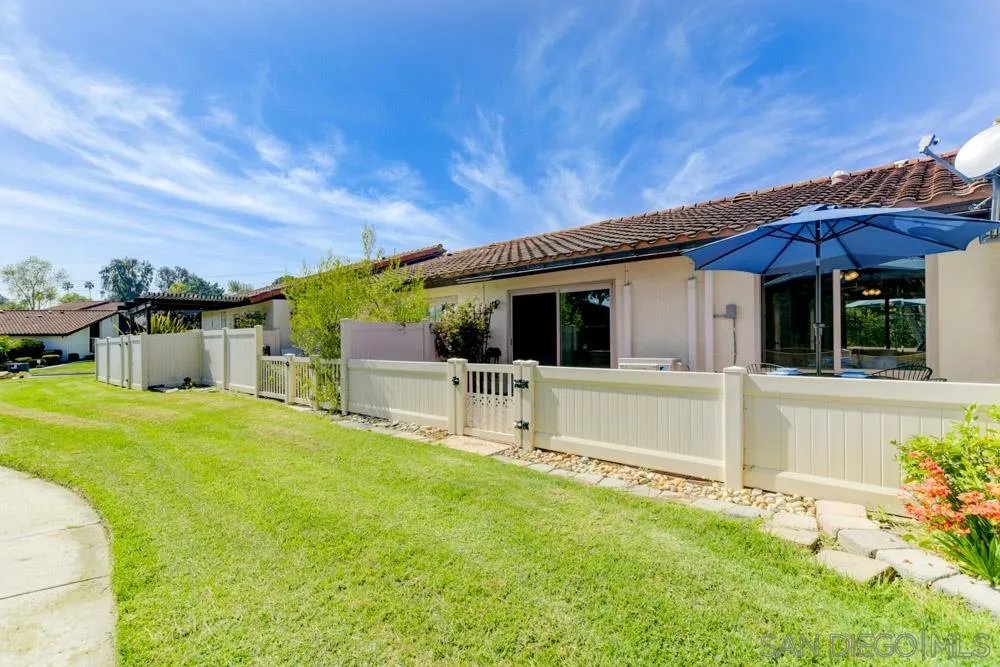 1750 Charleston Lane Encinitas, CA 92024 - Photo 23 of 25 a view of a white house with a big yard potted plants and large tree