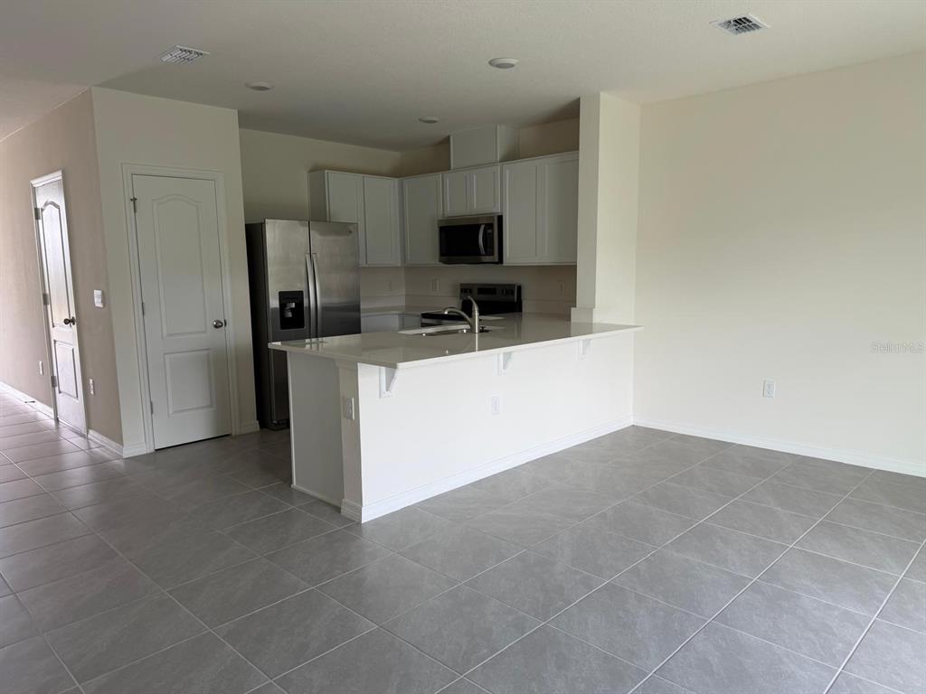 2195 Longleaf Road Davenport, FL 33837 - Photo 4 of 7 a kitchen with stainless steel appliances a refrigerator and a stove top oven