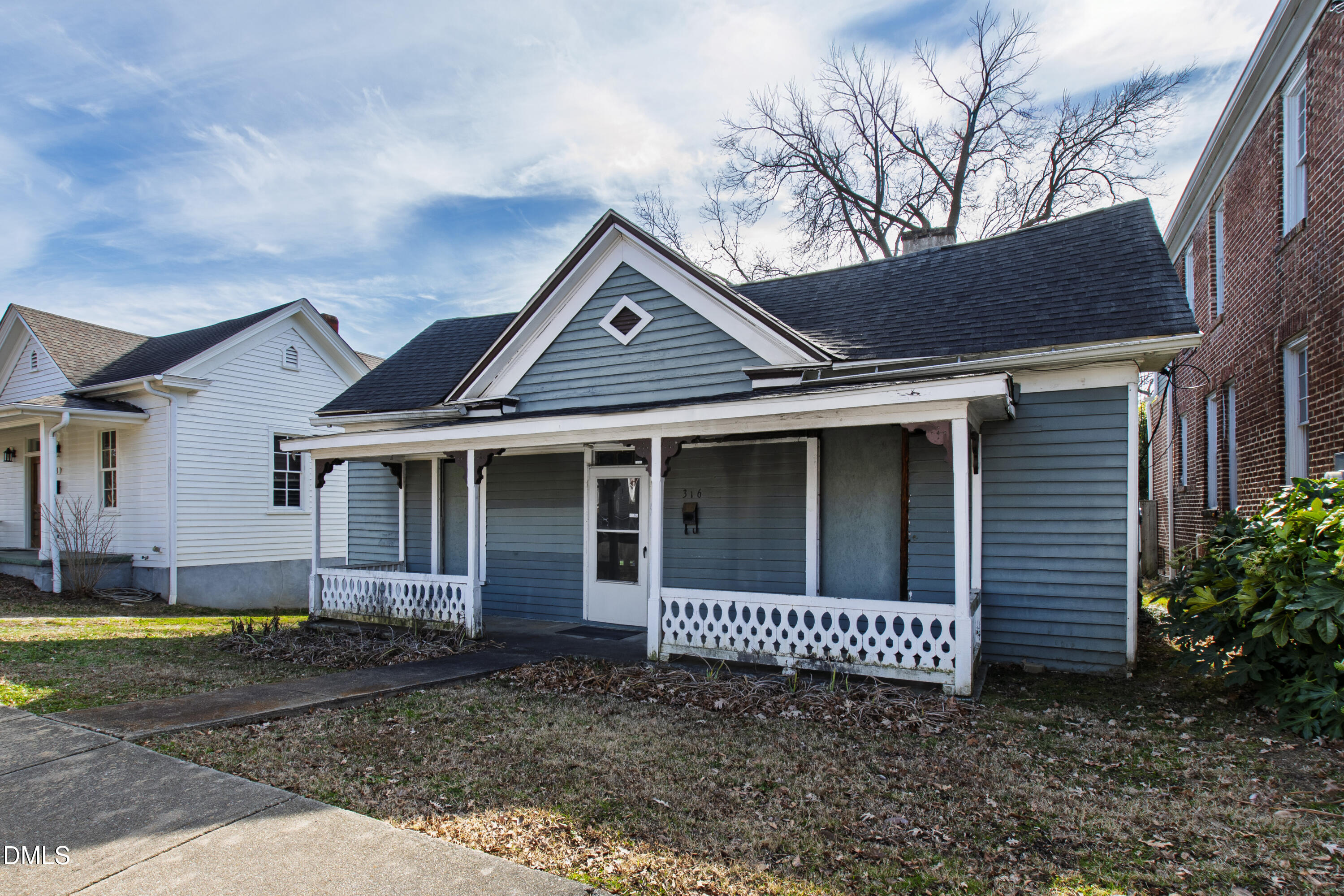 316 East Cabarrus Street Raleigh, NC 27601 - Photo 3 of 20 a view of a brick house with a yard plants and large tree