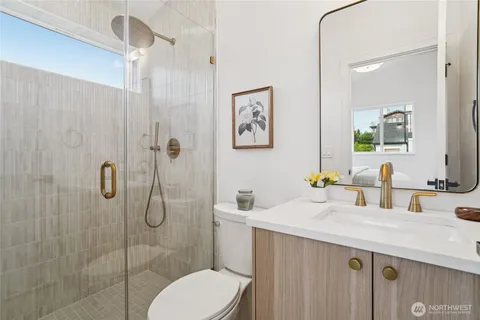 a bathroom with a granite countertop sink mirror and toilet