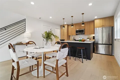 a kitchen with kitchen island a stove a chandelier a sink and a refrigerator