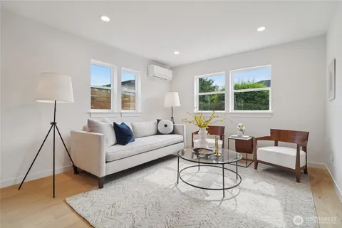 a living room with furniture a large window and a rug