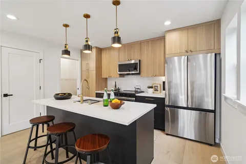 a kitchen with a sink a refrigerator and chairs