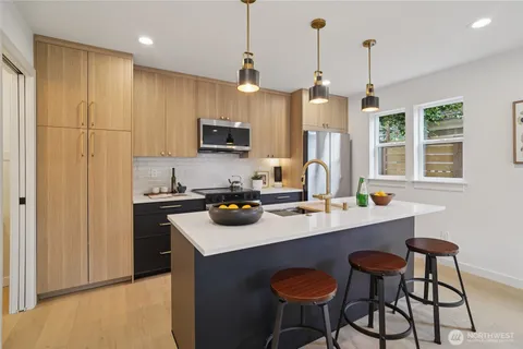 a kitchen with a sink a counter space appliances and cabinets