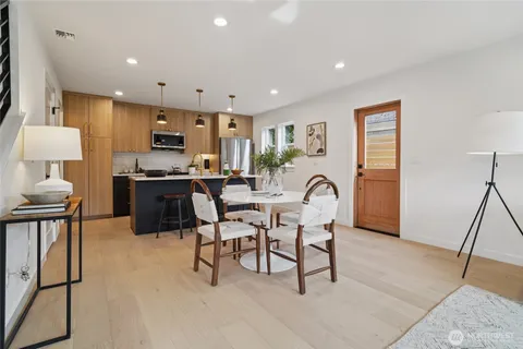 a living room with furniture a rug and kitchen space