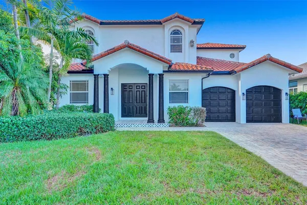 a front view of a house with a yard and garage