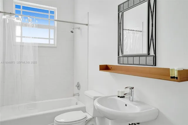 a white toilet sitting next to a bathroom sink