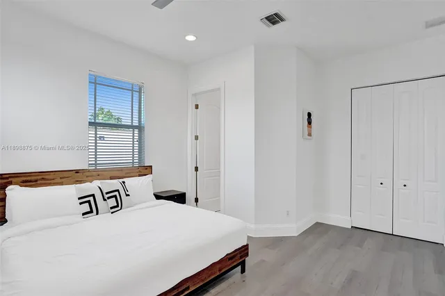 a backyard of a house with table and chairs under an umbrella
