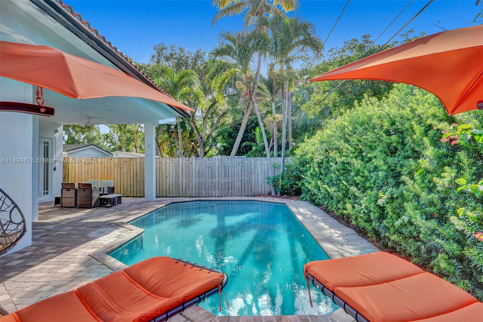 1207 Southwest 21st Street Fort Lauderdale, FL 33315 - Photo 57 of 81 a backyard of a house with table and chairs under an umbrella