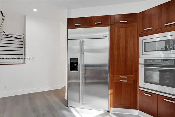 a kitchen with stainless steel appliances granite countertop a refrigerator and a stove top oven