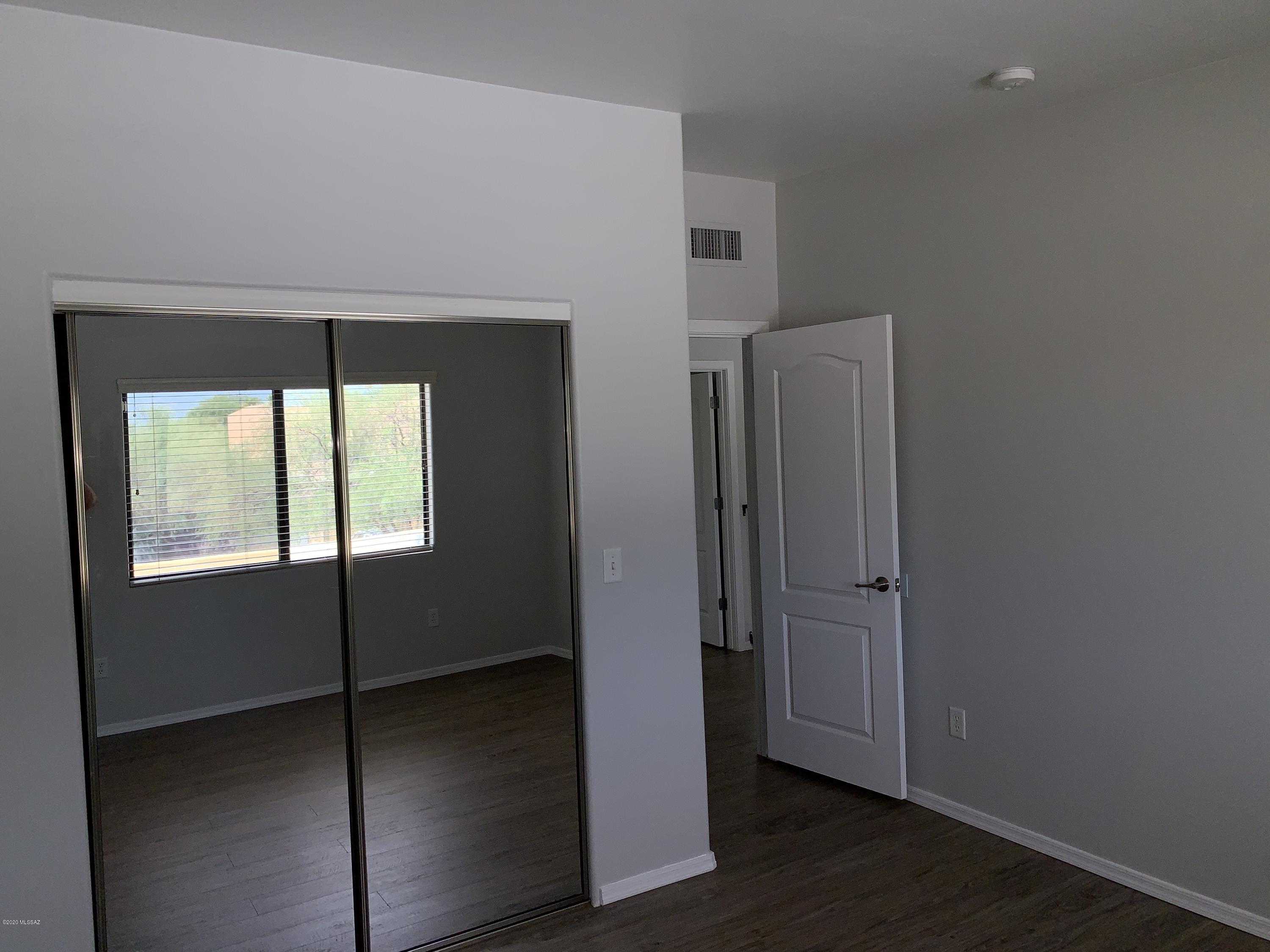 4181 North Fortune Loop Tucson, AZ 85719 - Photo 32 of 39 an empty room with wooden floor and a window