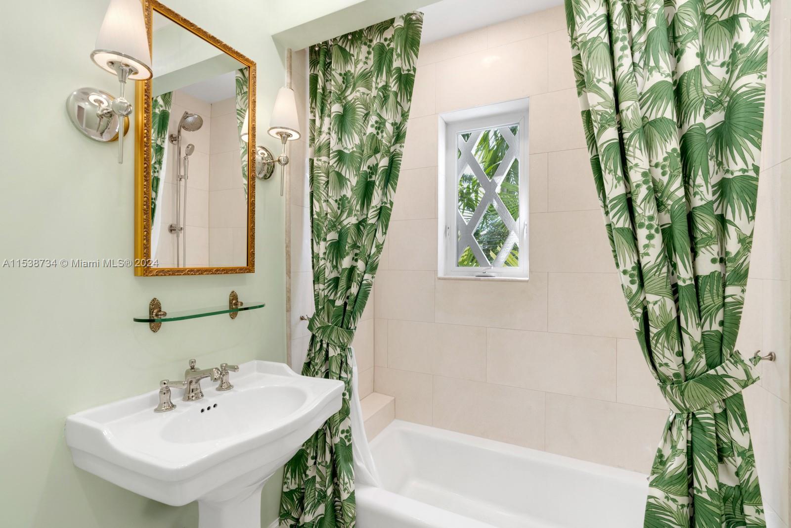 3685 Royal Palm Avenue Miami, FL 33133 - Photo 21 of 41 a bathroom with a sink a mirror and a shower curtain