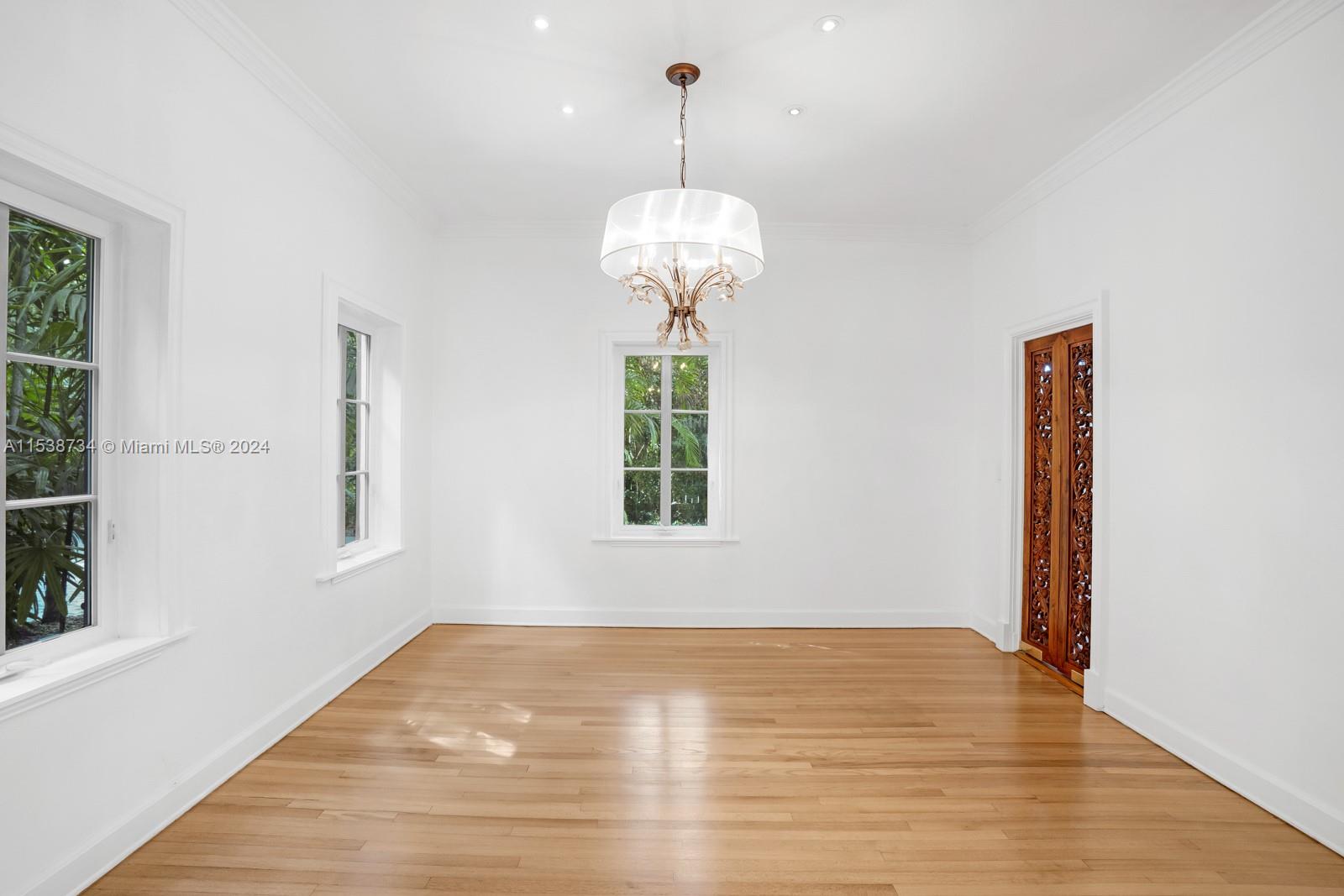 3685 Royal Palm Avenue Miami, FL 33133 - Photo 10 of 41 a view of a room with wooden floor chandelier and windows
