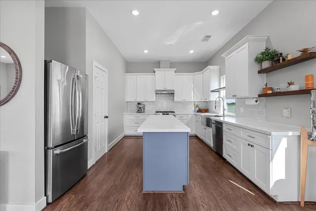 a large kitchen with stainless steel appliances sink a microwave and cabinets