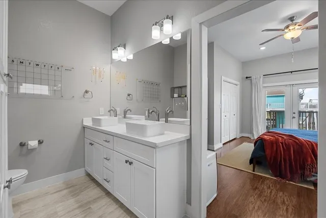 a en suite bathroom with a double vanity sink a toilet and a mirror