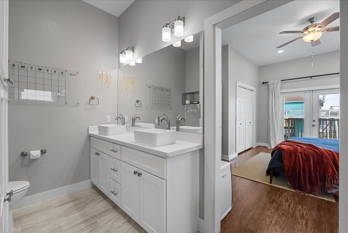1205 Todville Road Seabrook, TX 77586 - Photo 22 of 37 a en suite bathroom with a double vanity sink a toilet and a mirror
