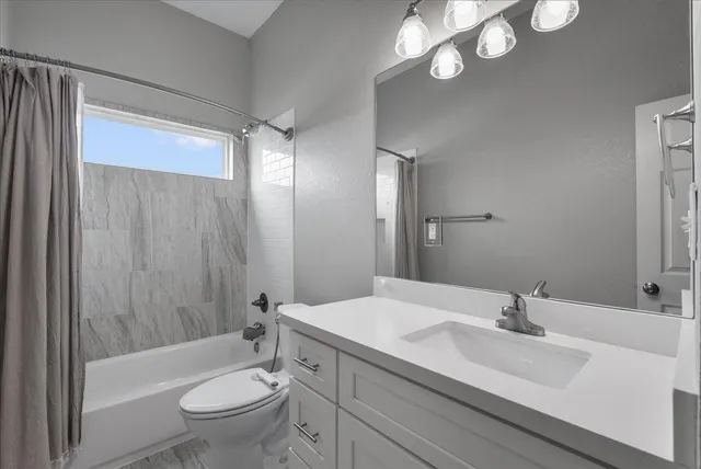 a bathroom with a sink a toilet a mirror and shower