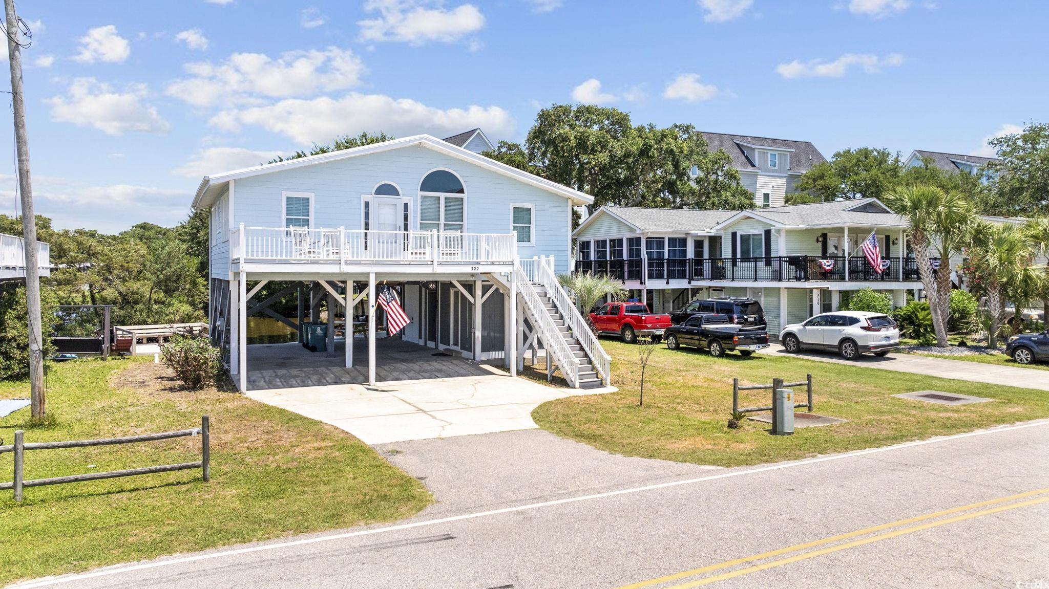 Coastal inspired home featuring a carport and a front lawn